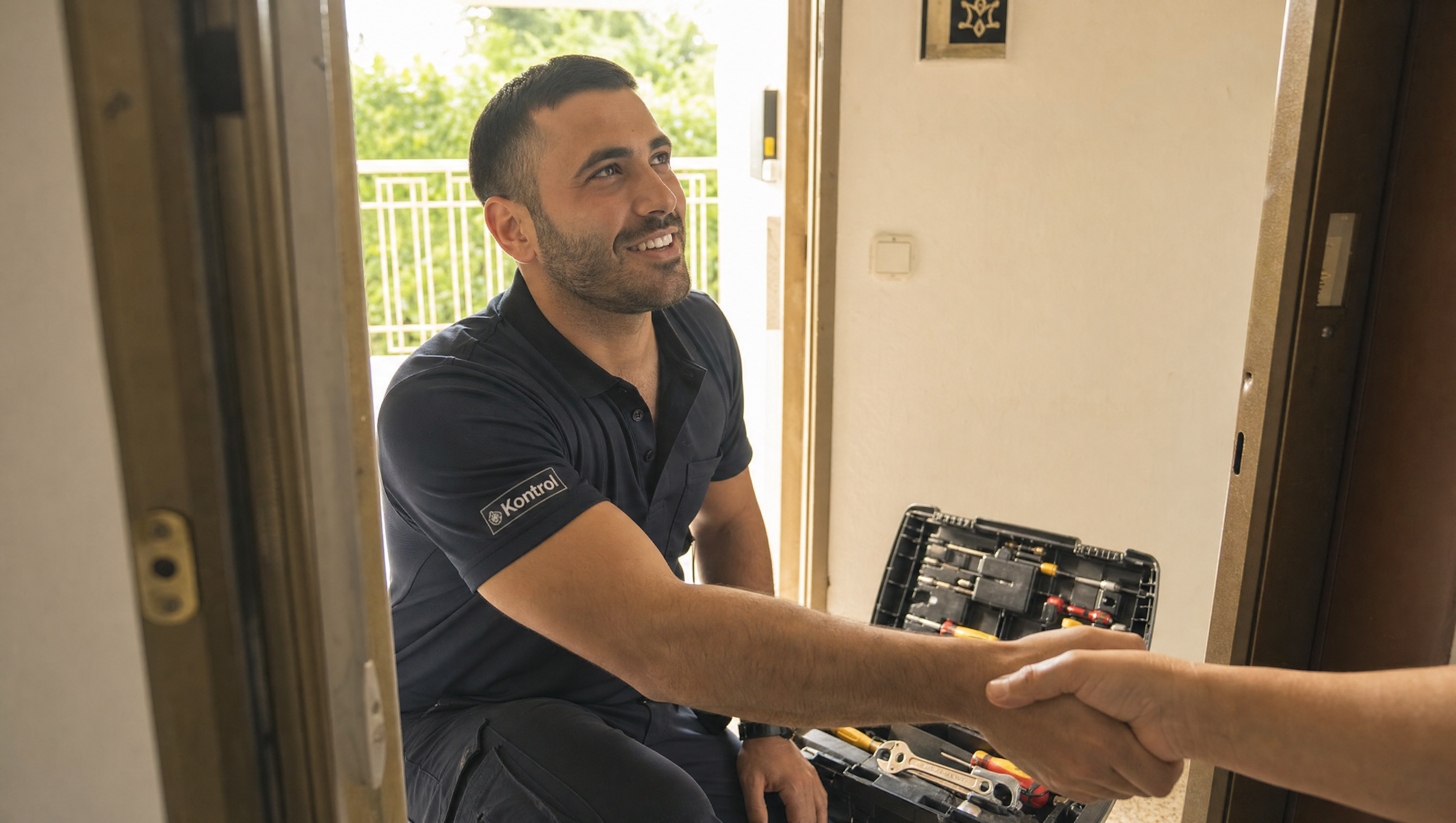 Photo of Kontrol technician at customer's door — uniformed (subtle Kontrol patch), friendly, with toolkit, working on lock. Warm context, hand-shake or smile moment.